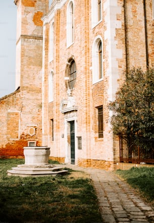 a large brick building with a fountain in front of it