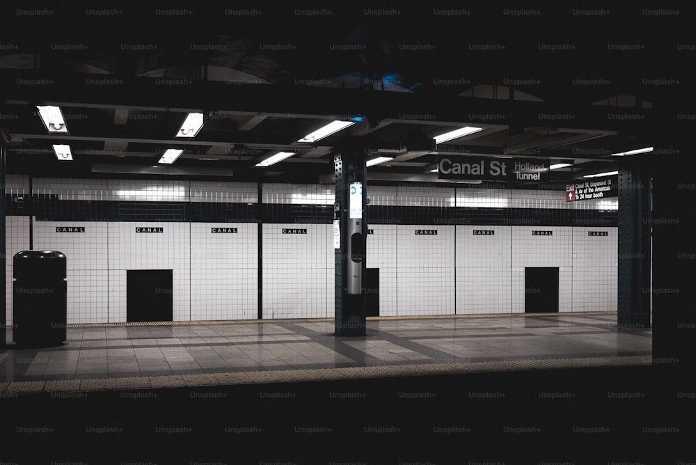 a subway station with a black and white tiled floor