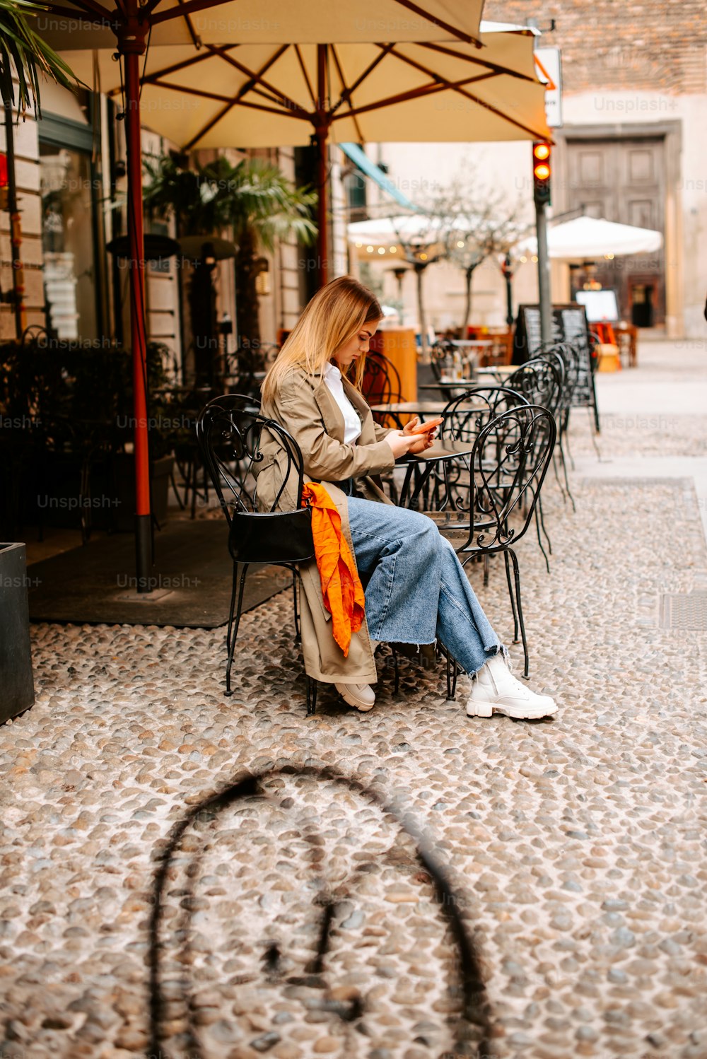 Una mujer sentada en una silla en un café al aire libre
