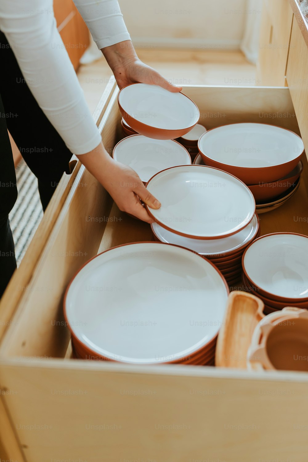 a person holding a box full of plates