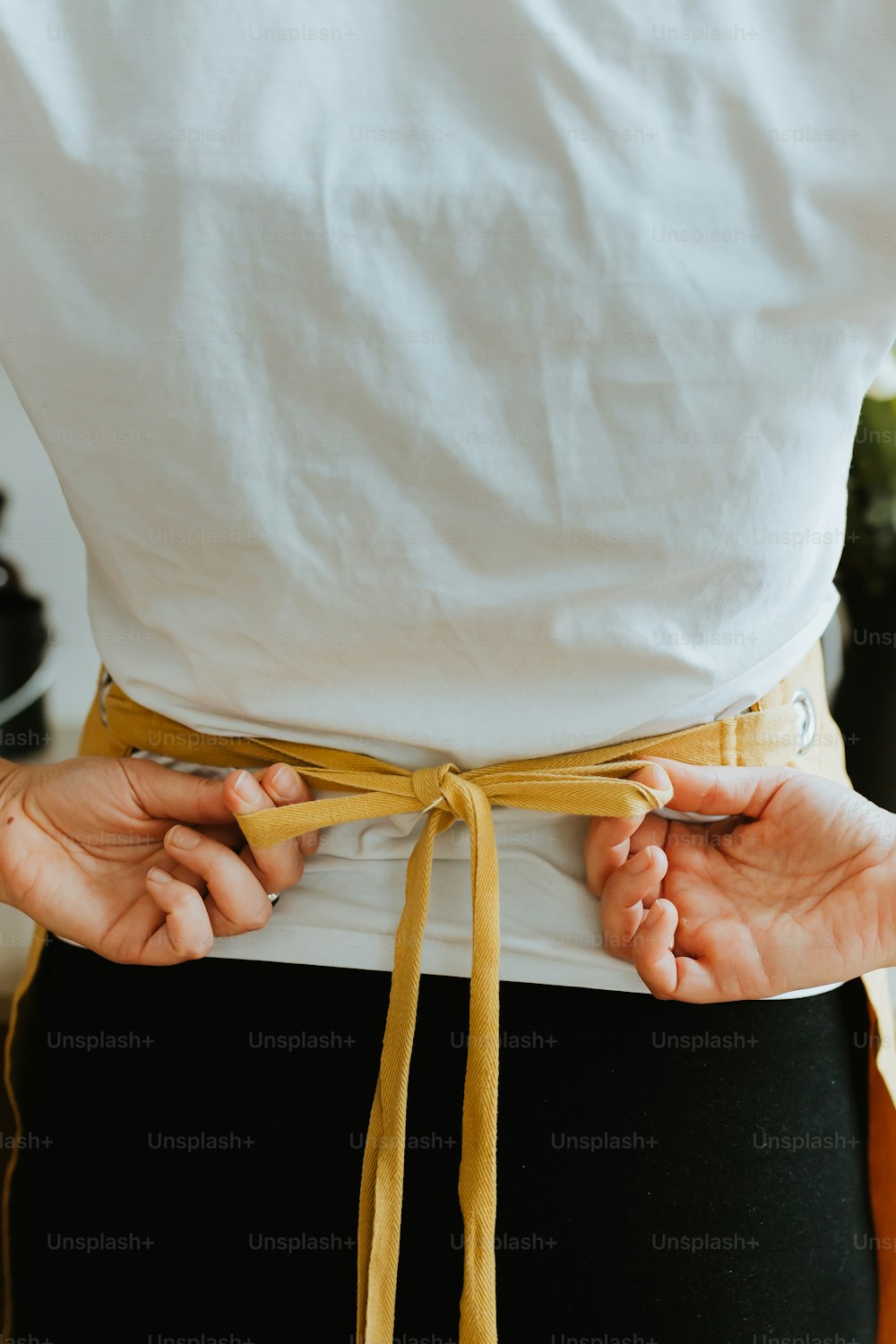 a person wearing a white shirt and a yellow belt