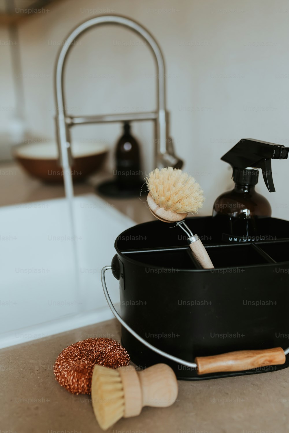 a black bucket with a brush and a soap dispenser