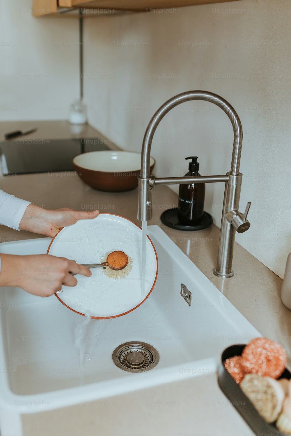 a woman is holding a plate over a sink