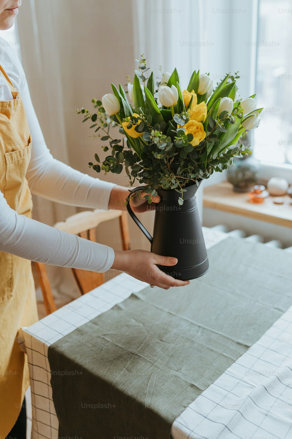 a woman is holding a vase with flowers in it