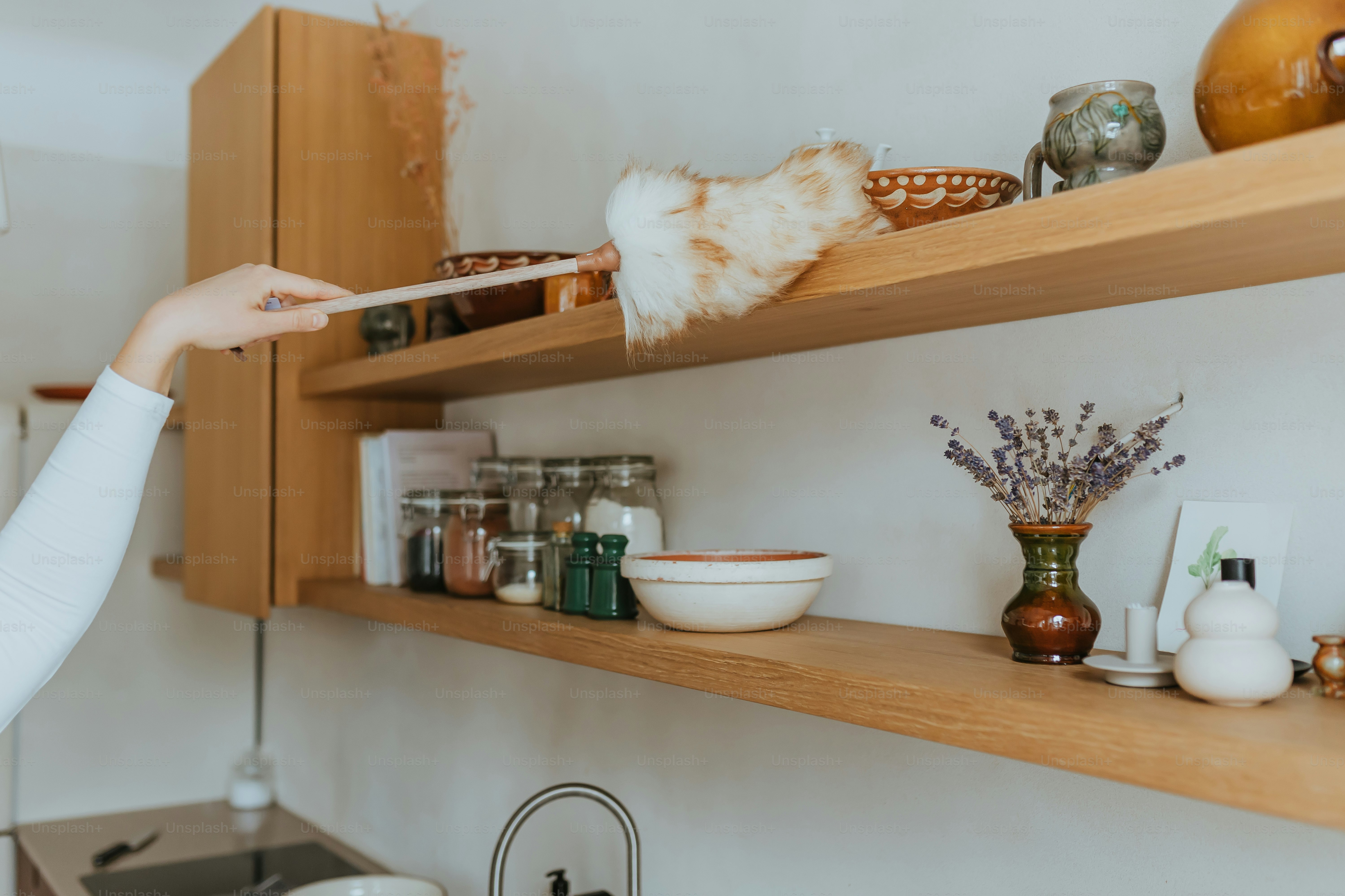 Una donna che pulisce uno scaffale in una cucina