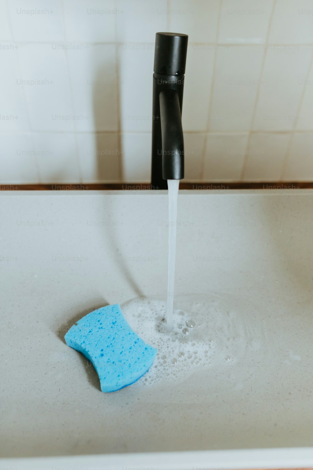 a blue sponge is being washed in a sink