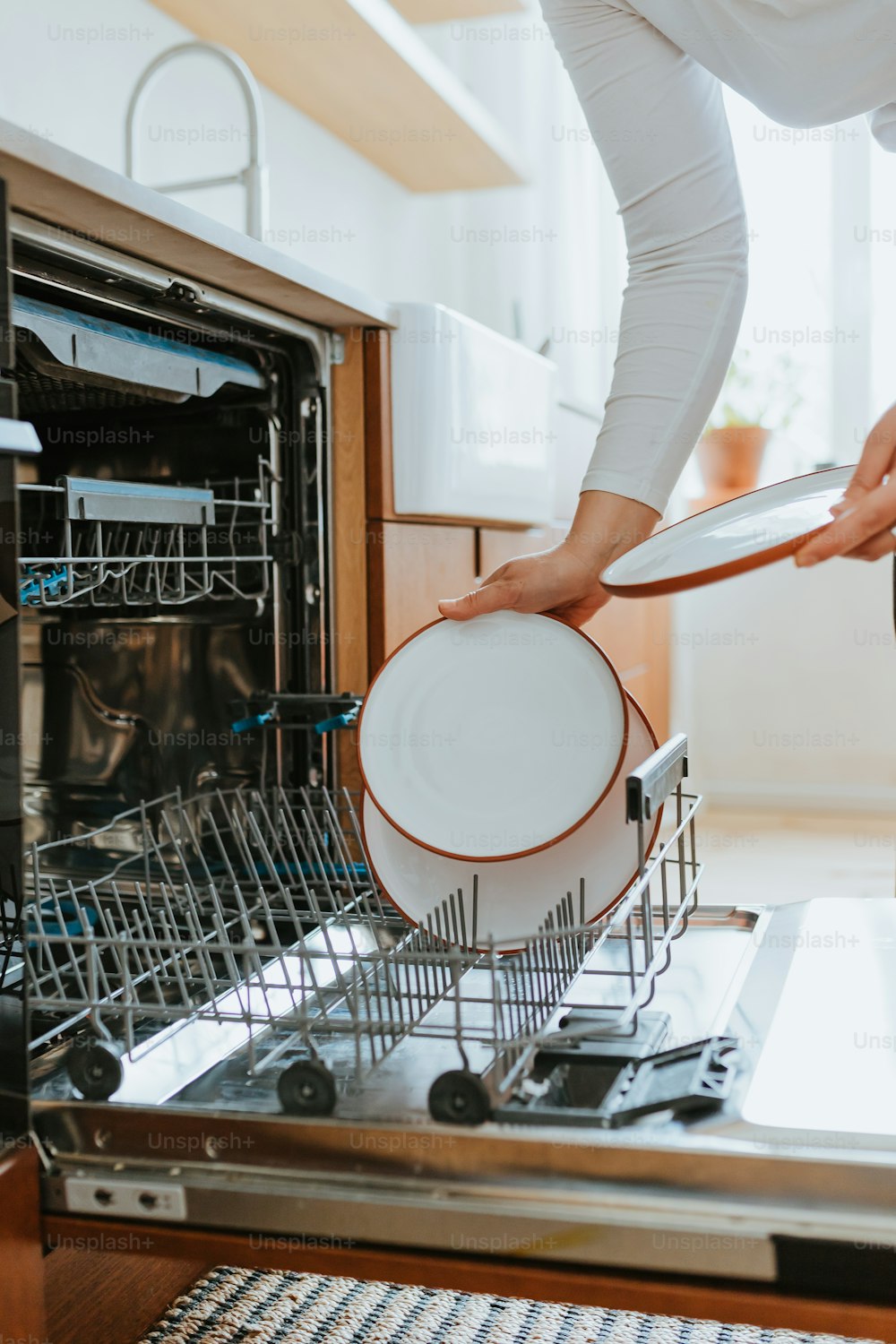 a woman is holding a dishwasher in her hand