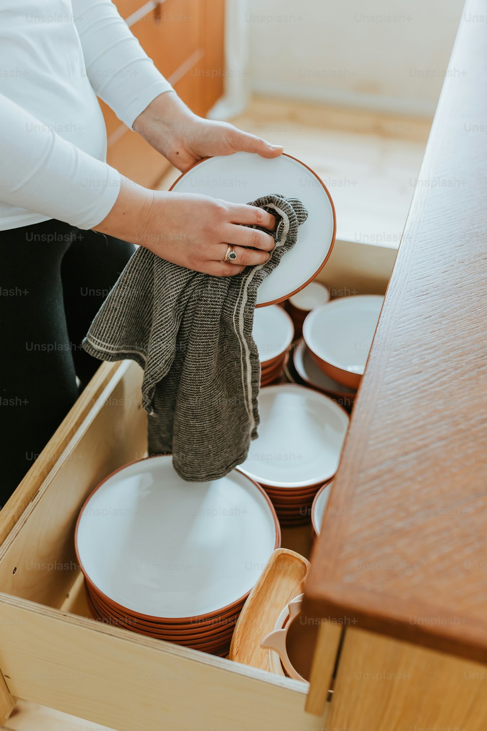 a woman is holding a plate in a drawer
