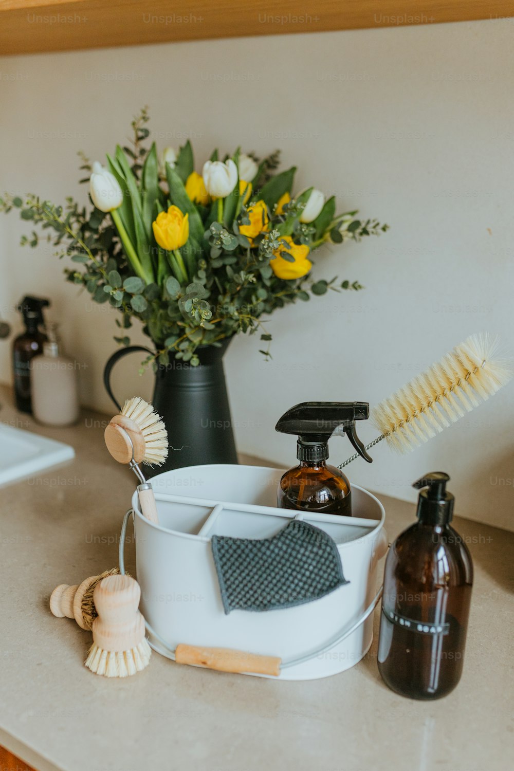 um balcão com um vaso de flores e um secador de cabelo