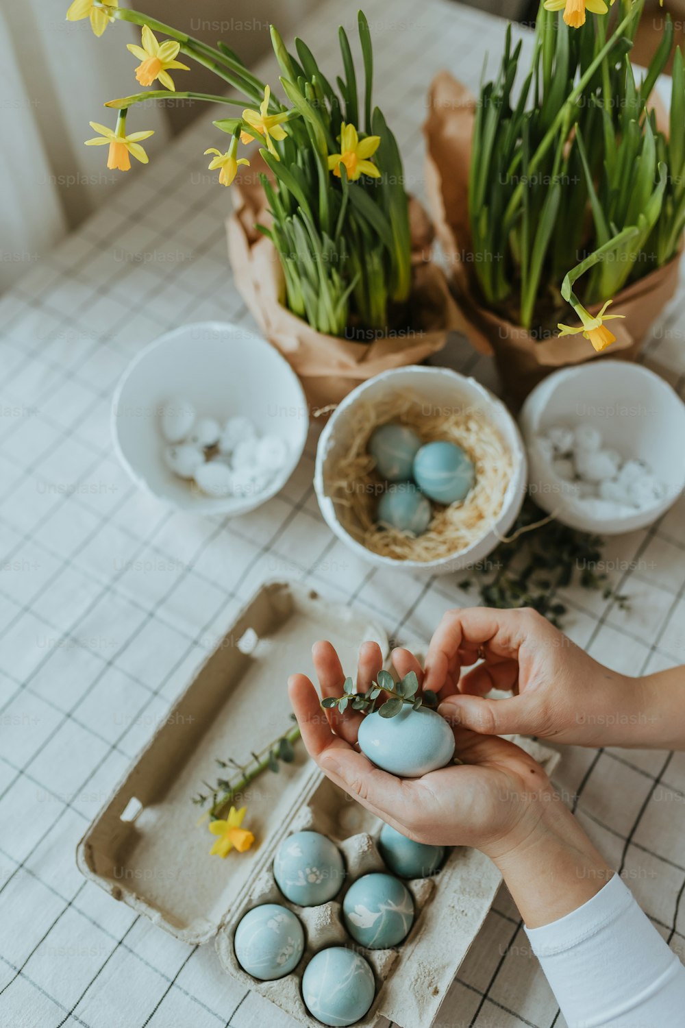 a person holding a small egg in front of some flowers