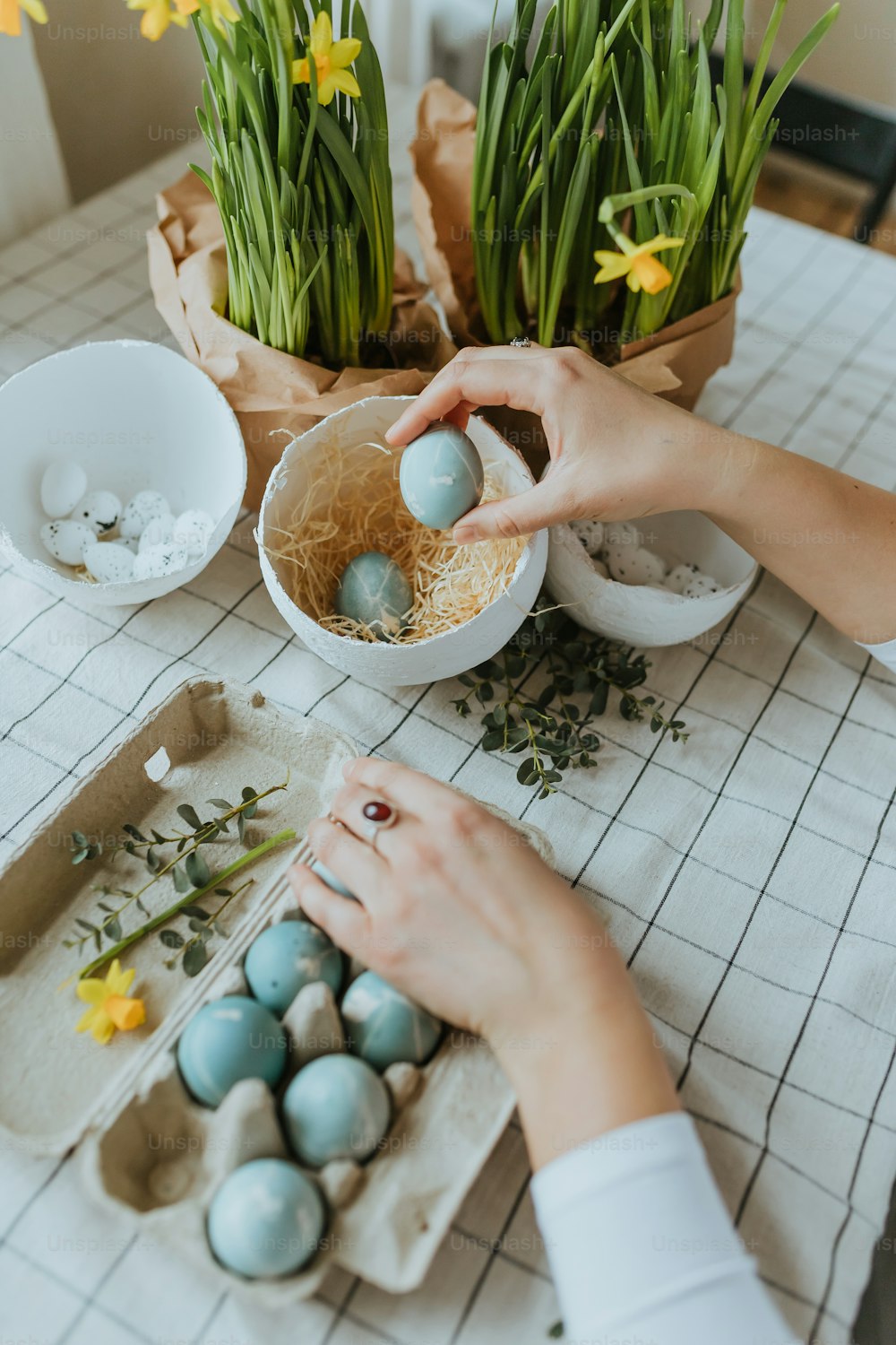 a woman is putting eggs in a bowl on a table