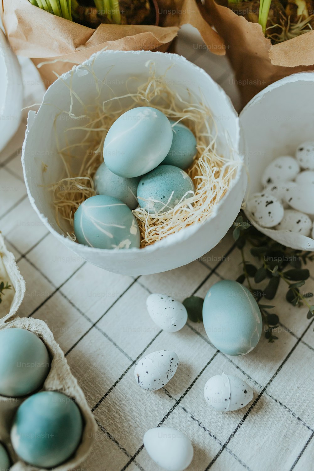 una ciotola piena di uova blu e bianche in cima a un tavolo