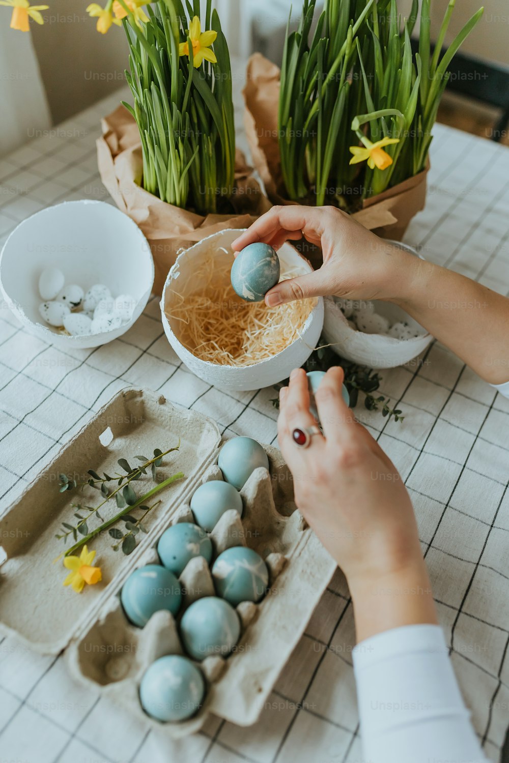 Una persona está decorando unos huevos en una mesa