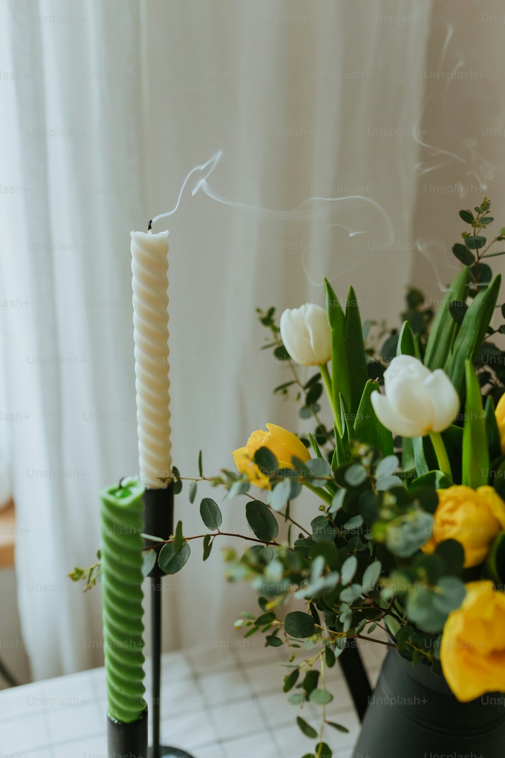 un vaso con fiori e una candela su un tavolo
