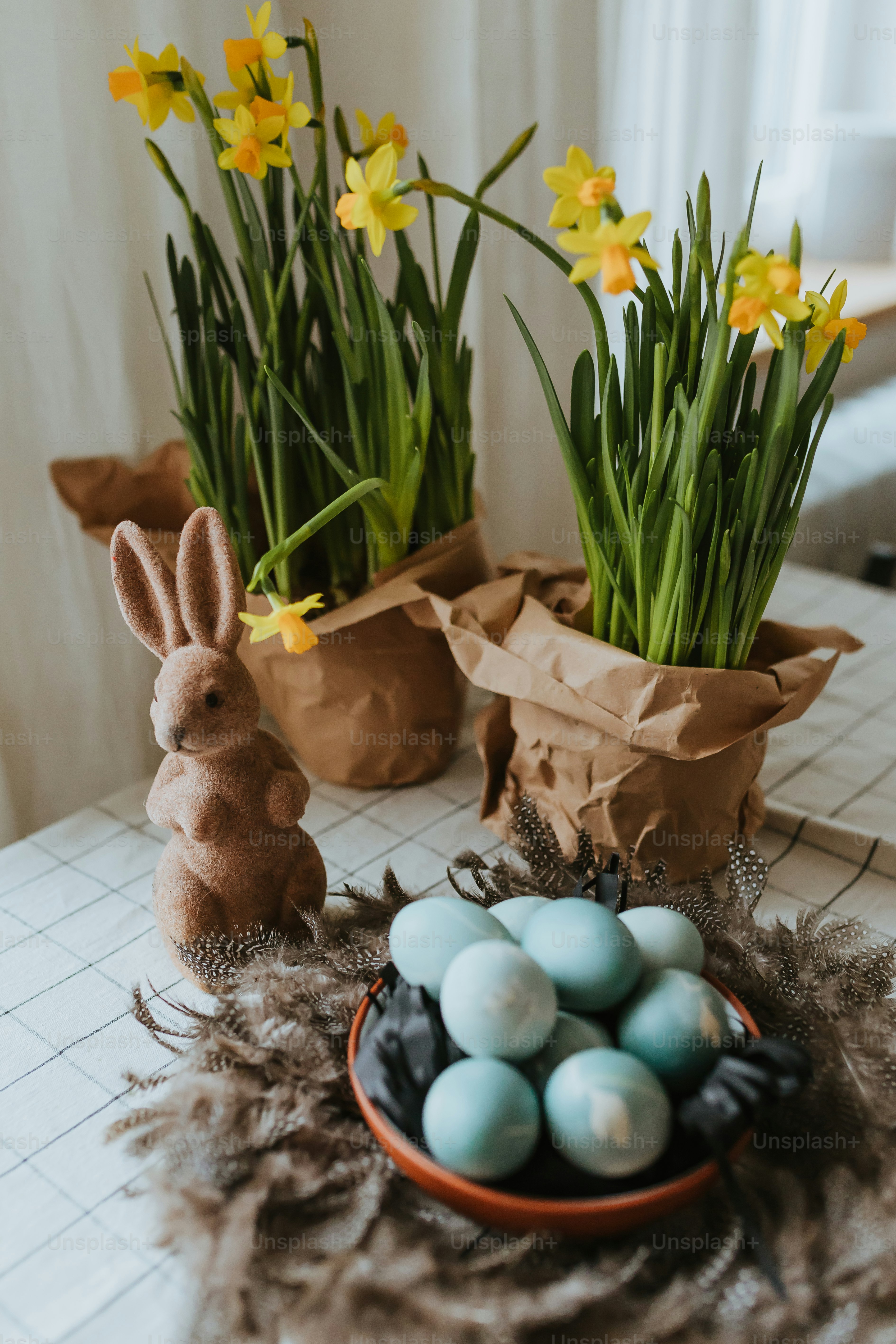 A table topped with a bowl filled with eggs and flowers photo – Spring ...
