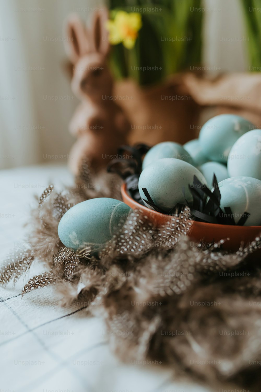 a bowl filled with blue eggs on top of a table