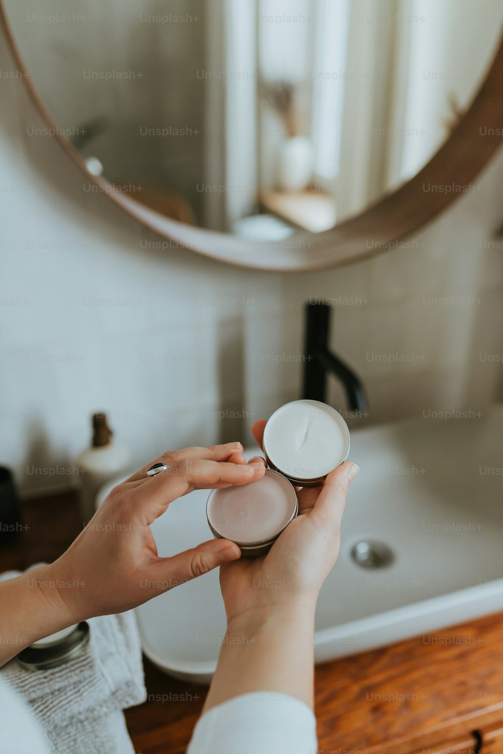 a woman is holding a white candle in front of a mirror