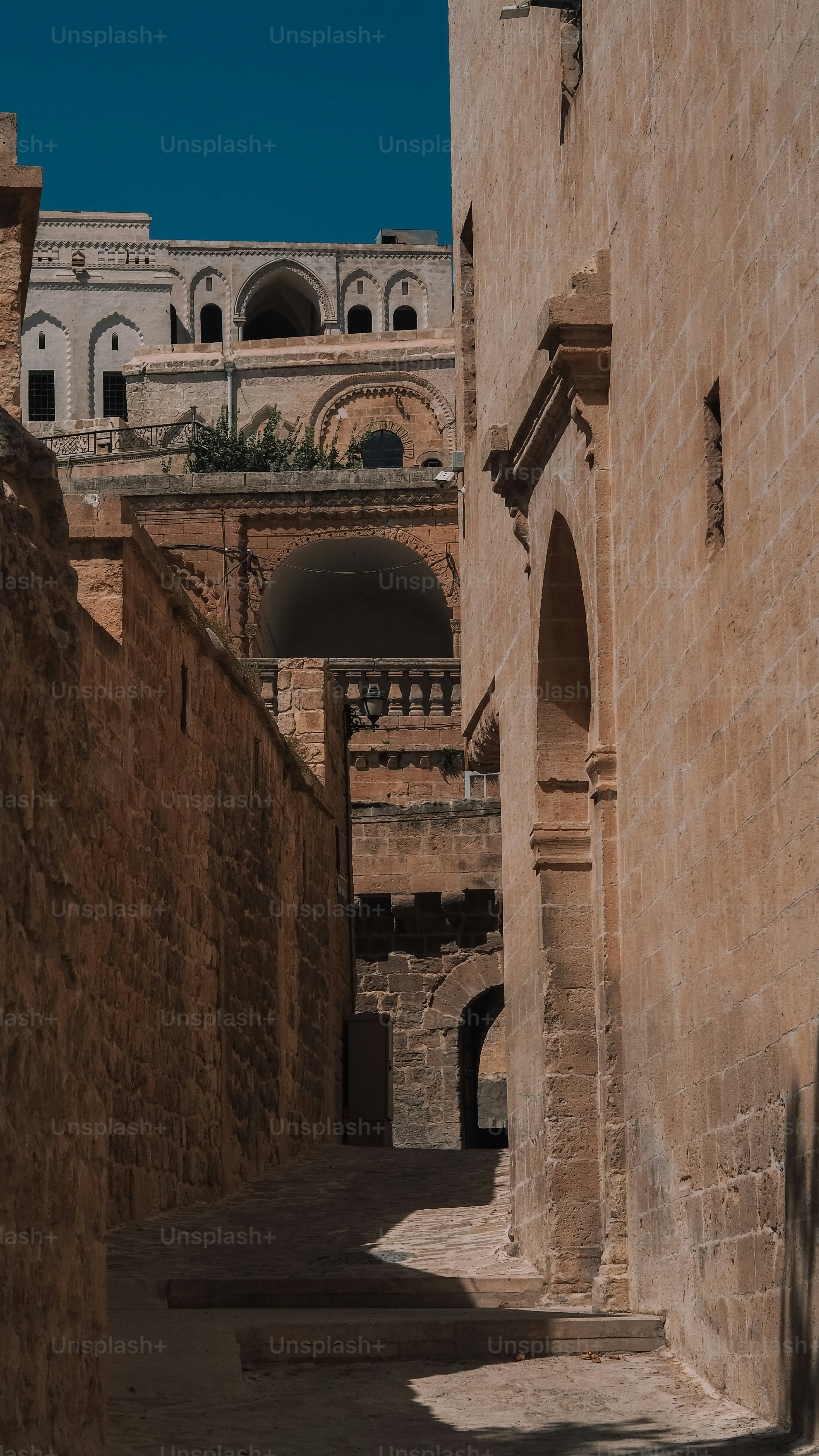 eine schmale Gasse mit einem Uhrturm im Hintergrund