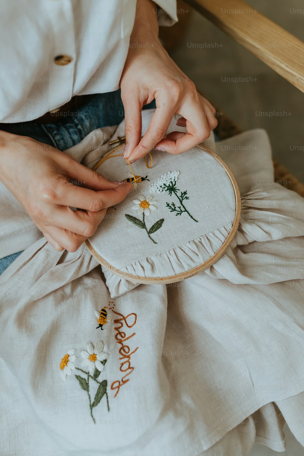 a woman is working on a embroidery project