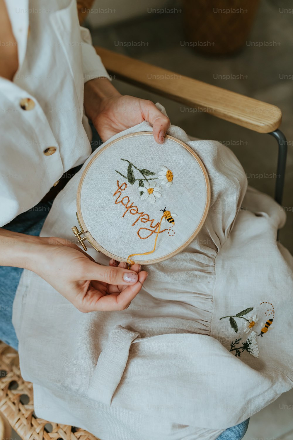 a woman is holding a happy birthday cross stitch