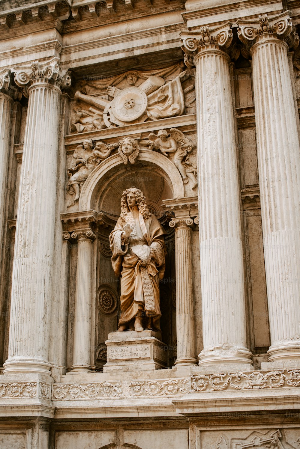 una estatua de un hombre sentado en la parte superior de un edificio