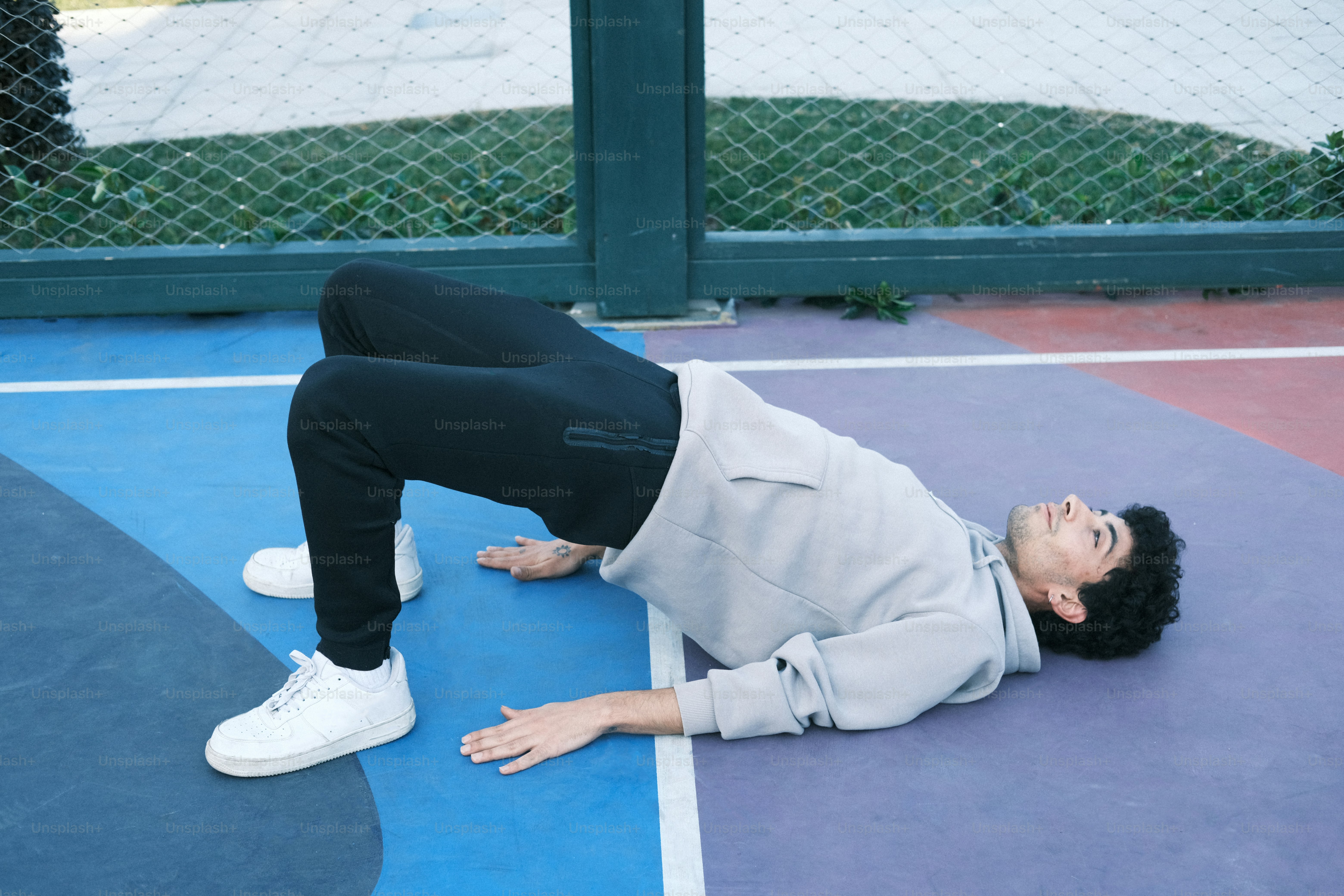 a person laying on a tennis court with a tennis racket