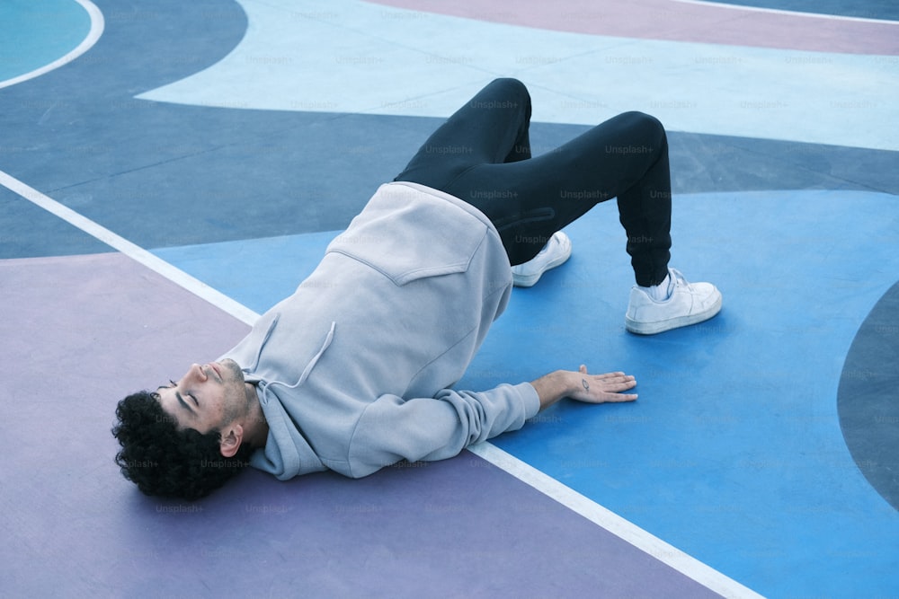 a man laying on his back on a basketball court