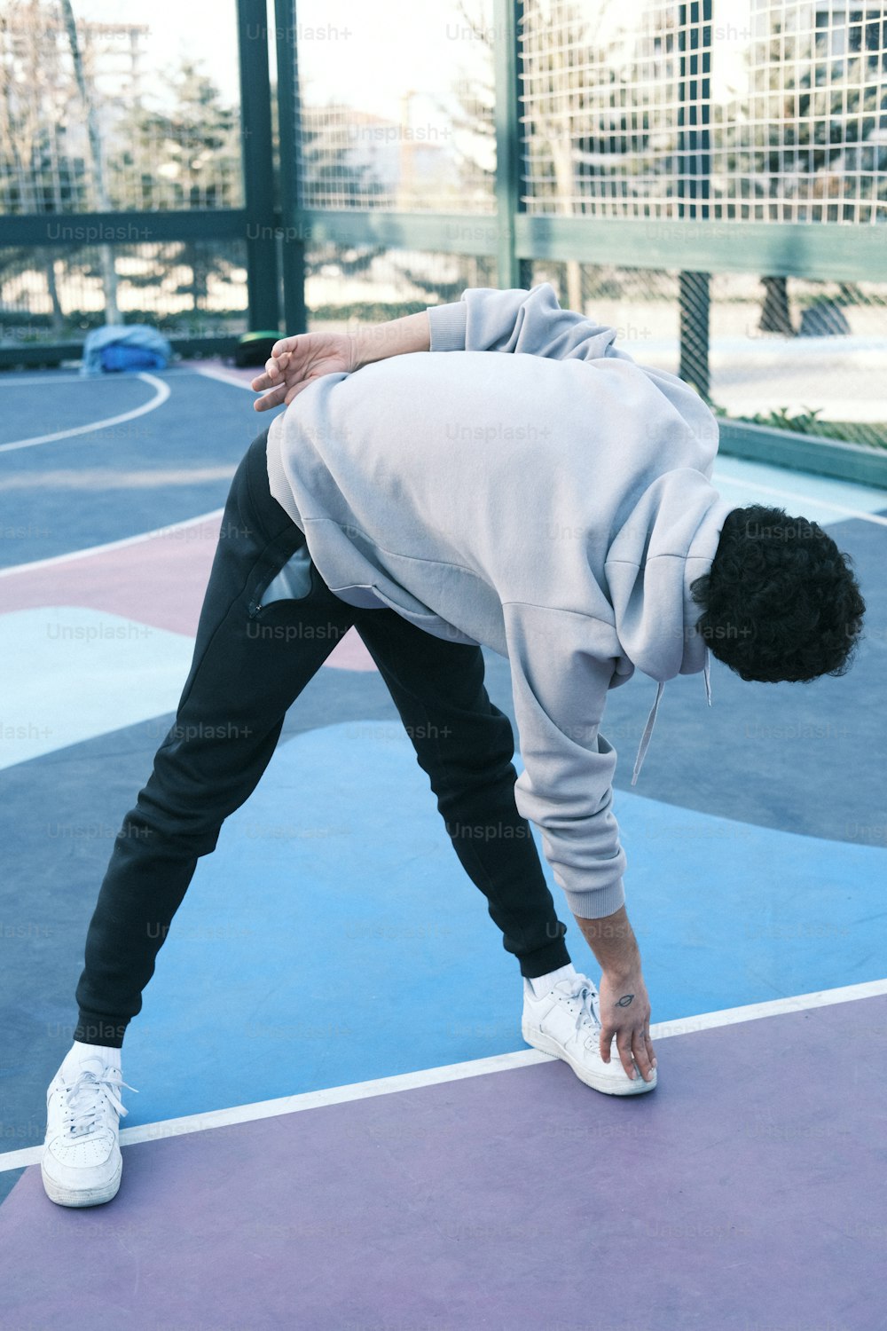 a person bending over on a tennis court