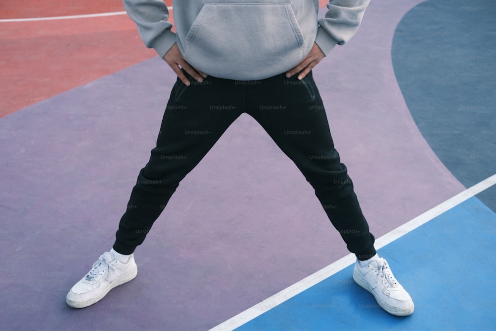 a man standing on a basketball court with his hands on his hips