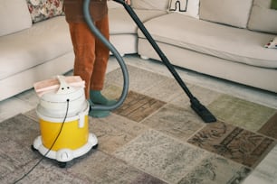 a person using a vacuum cleaner on the floor