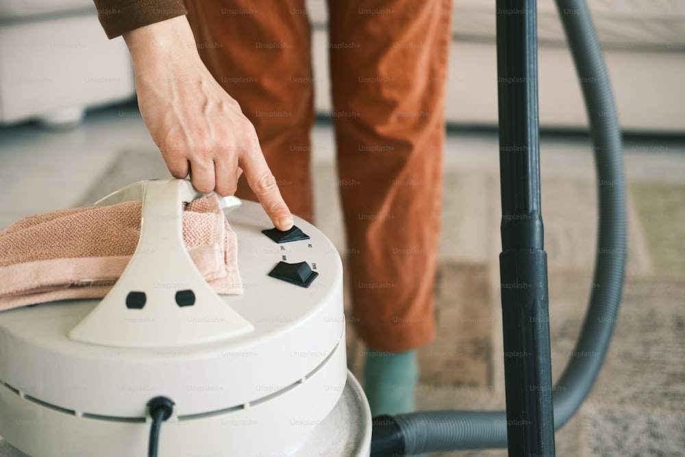 a person using a vacuum cleaner on a carpet