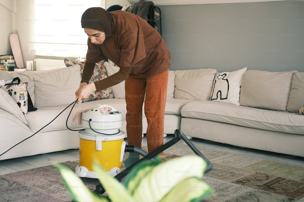 Una donna che usa un aspirapolvere per pulire un soggiorno
