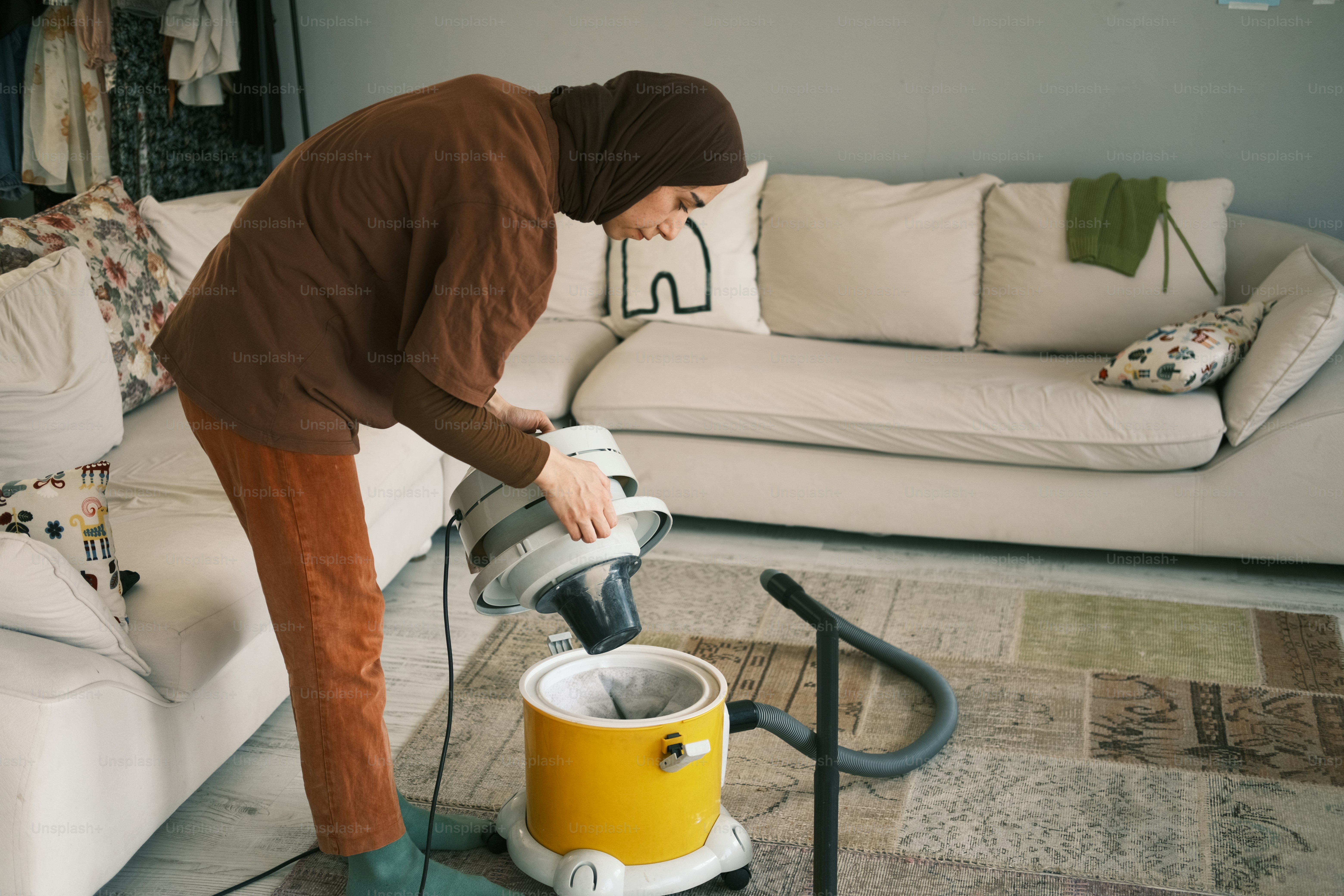 a woman is using a vacuum to clean the floor