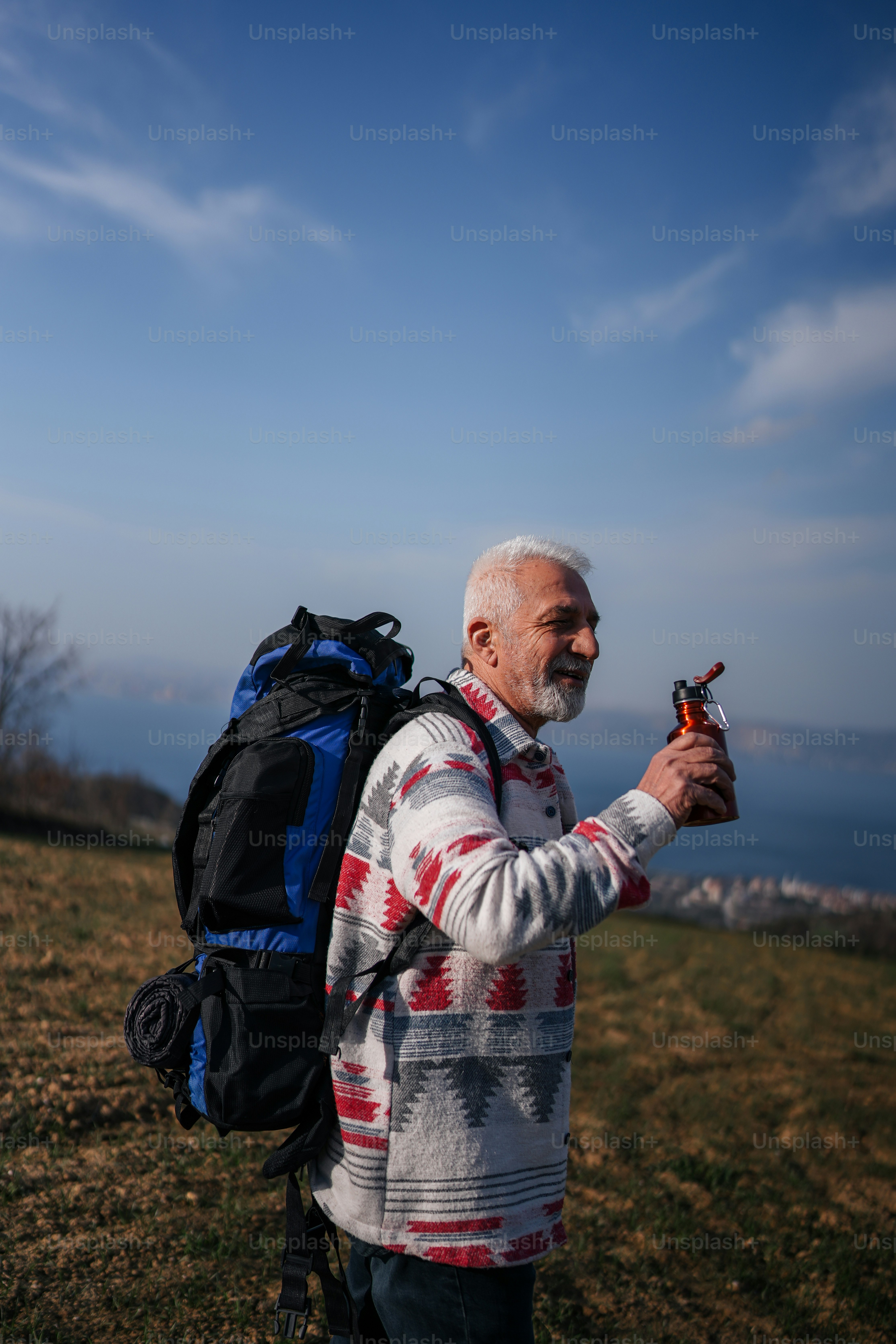 Long-distance backpacker using GPS watches for hiking on a mountain trail during sunrise