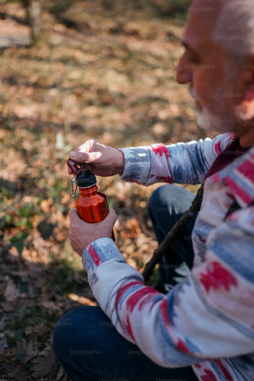 Ein Mann sitzt auf dem Boden und hält eine Flasche in der Hand