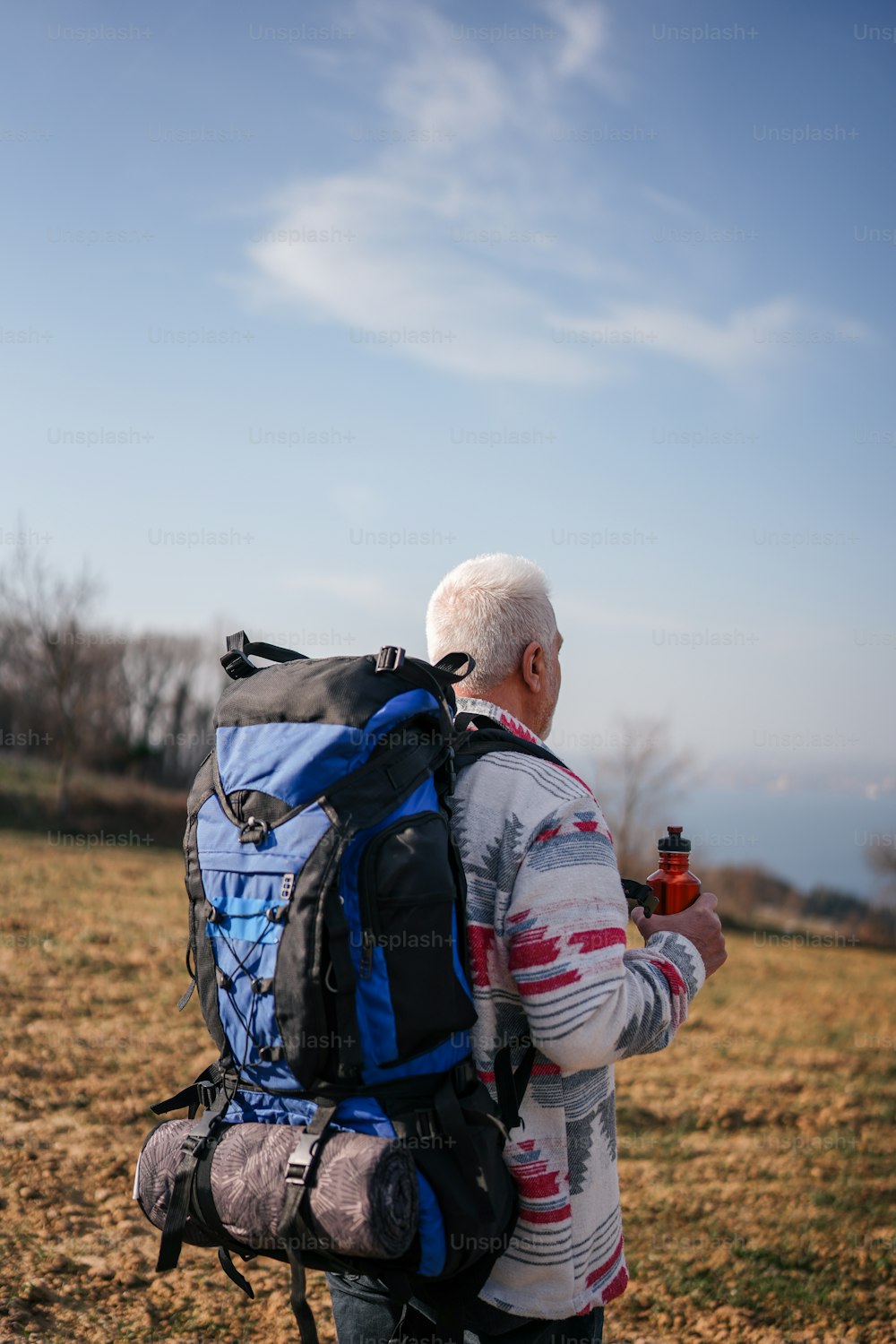 um homem com uma mochila e uma garrafa de cerveja