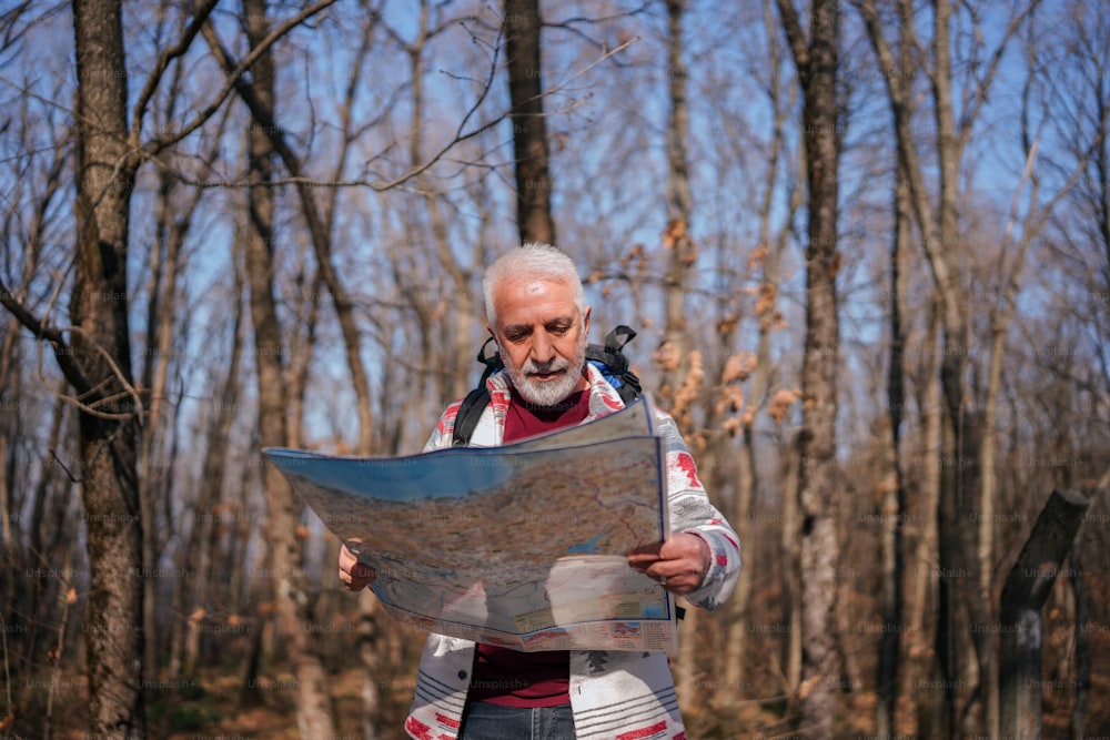 a man in the woods looking at a map