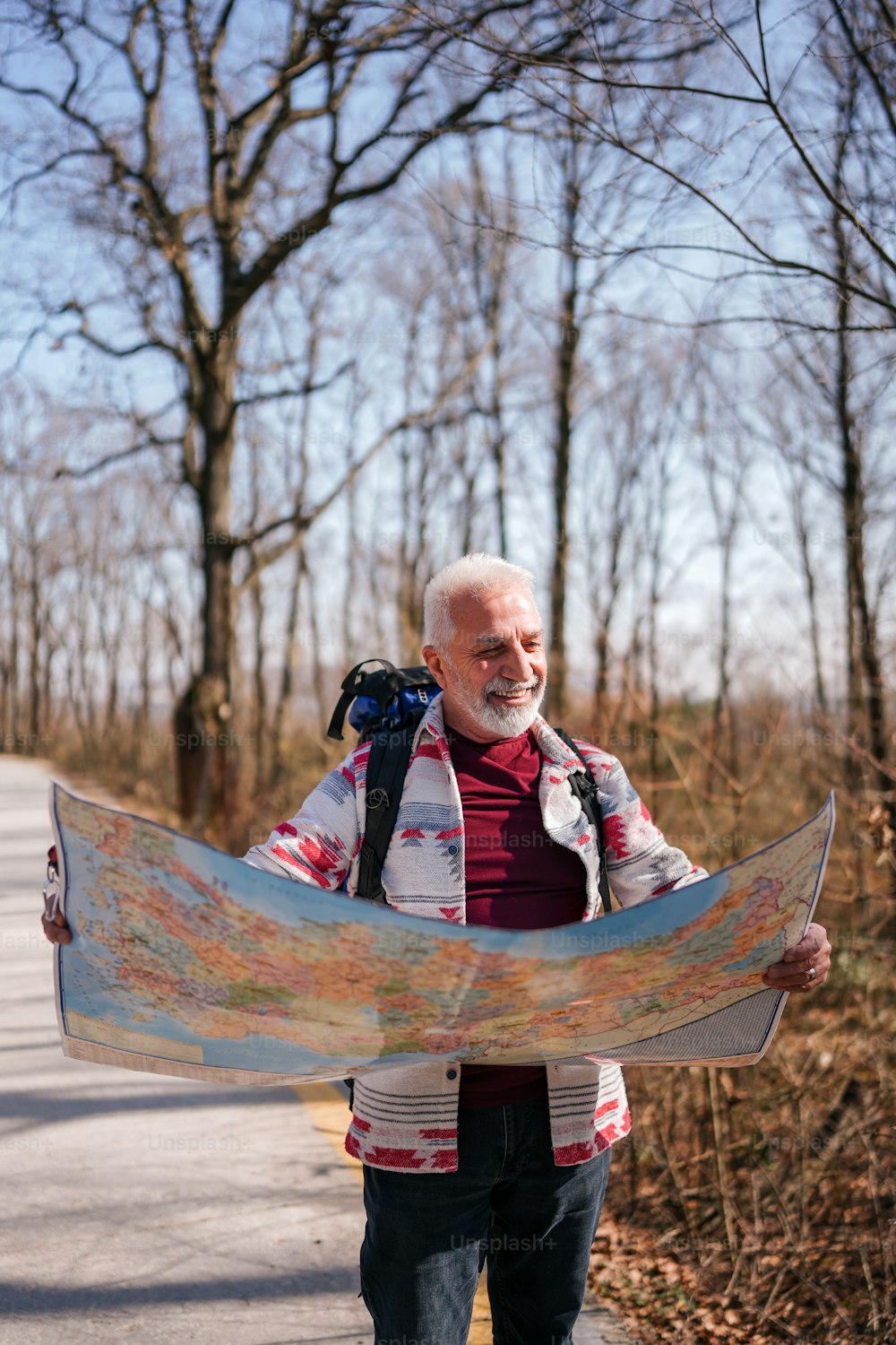 um homem segurando um mapa enquanto caminha por uma estrada