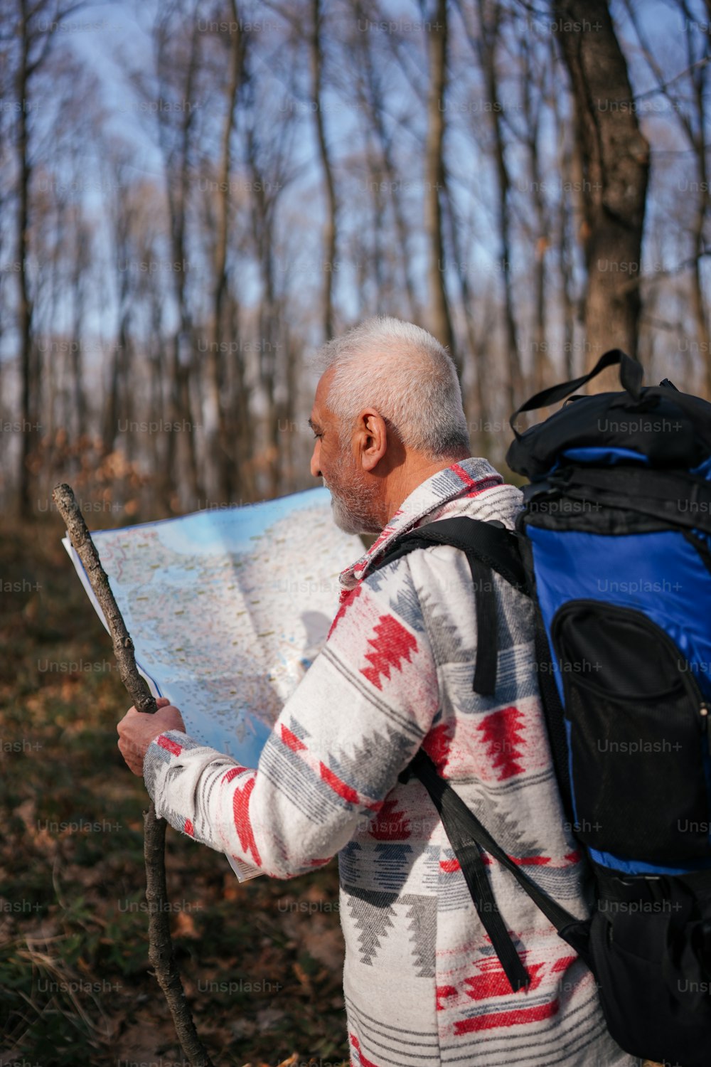Un uomo con uno zaino che guarda una mappa