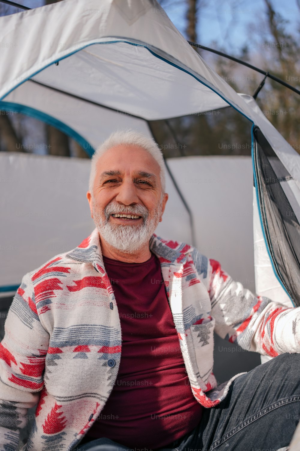 Un uomo seduto davanti a una tenda sorridente
