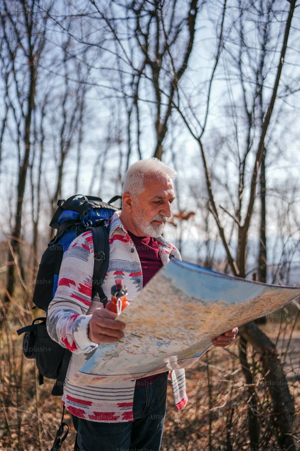 Ein Mann mit einem Rucksack schaut auf eine Karte