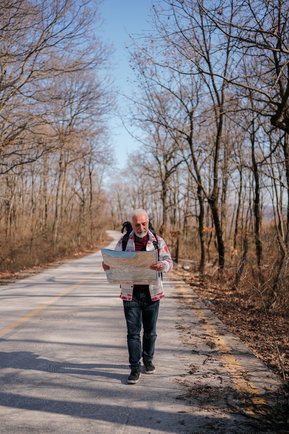 a man walking down a road holding a map
