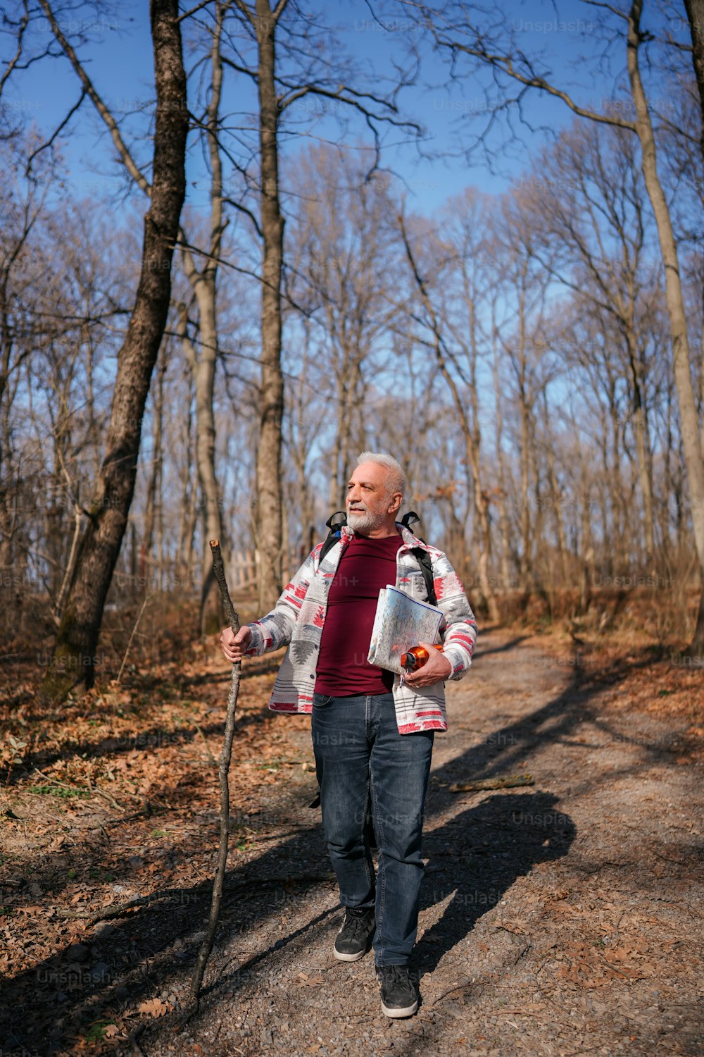 Ein Mann geht einen Feldweg im Wald entlang