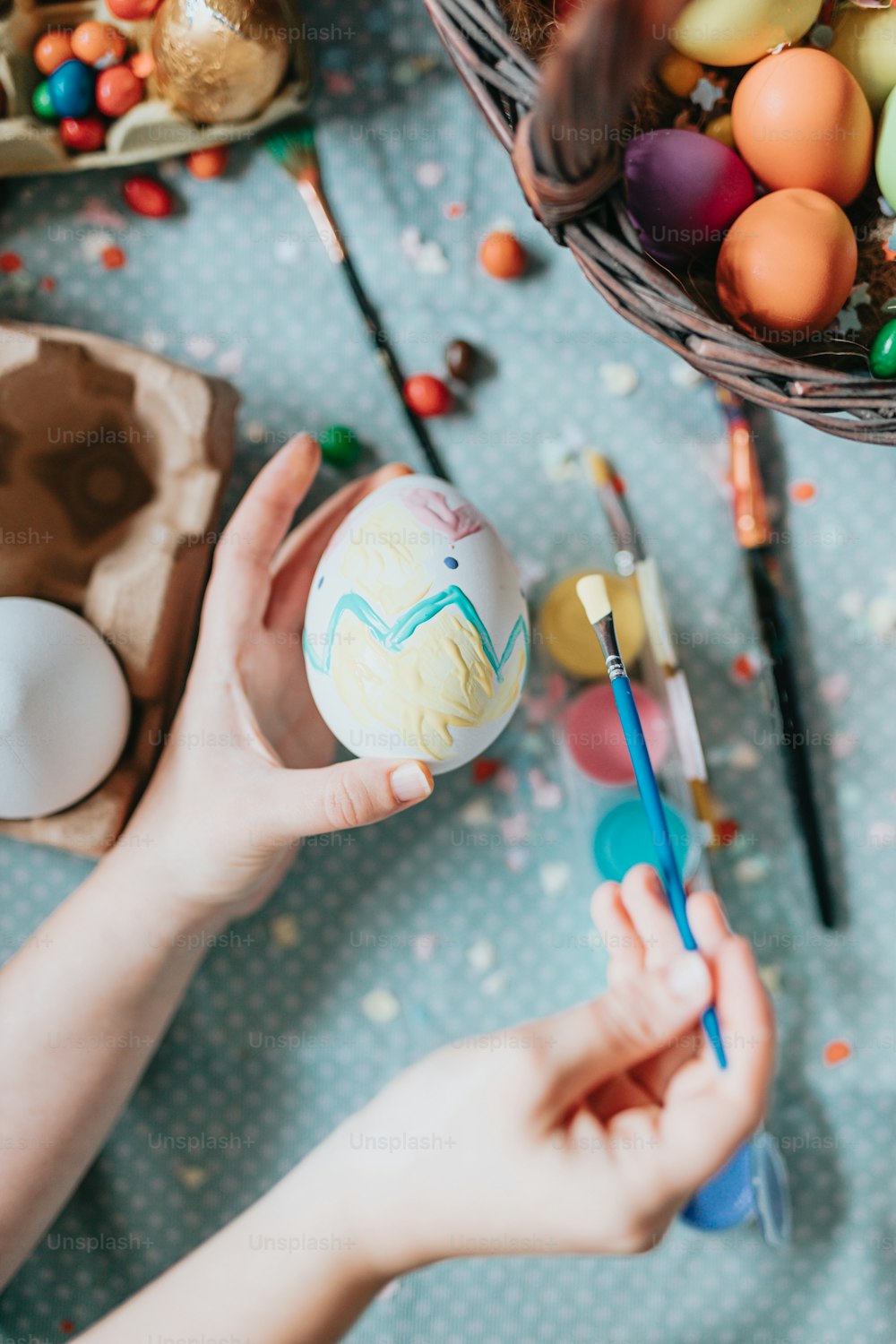 a person painting an egg with a brush