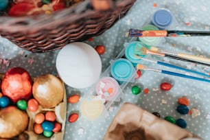 a basket full of eggs, paint, and other items on a table