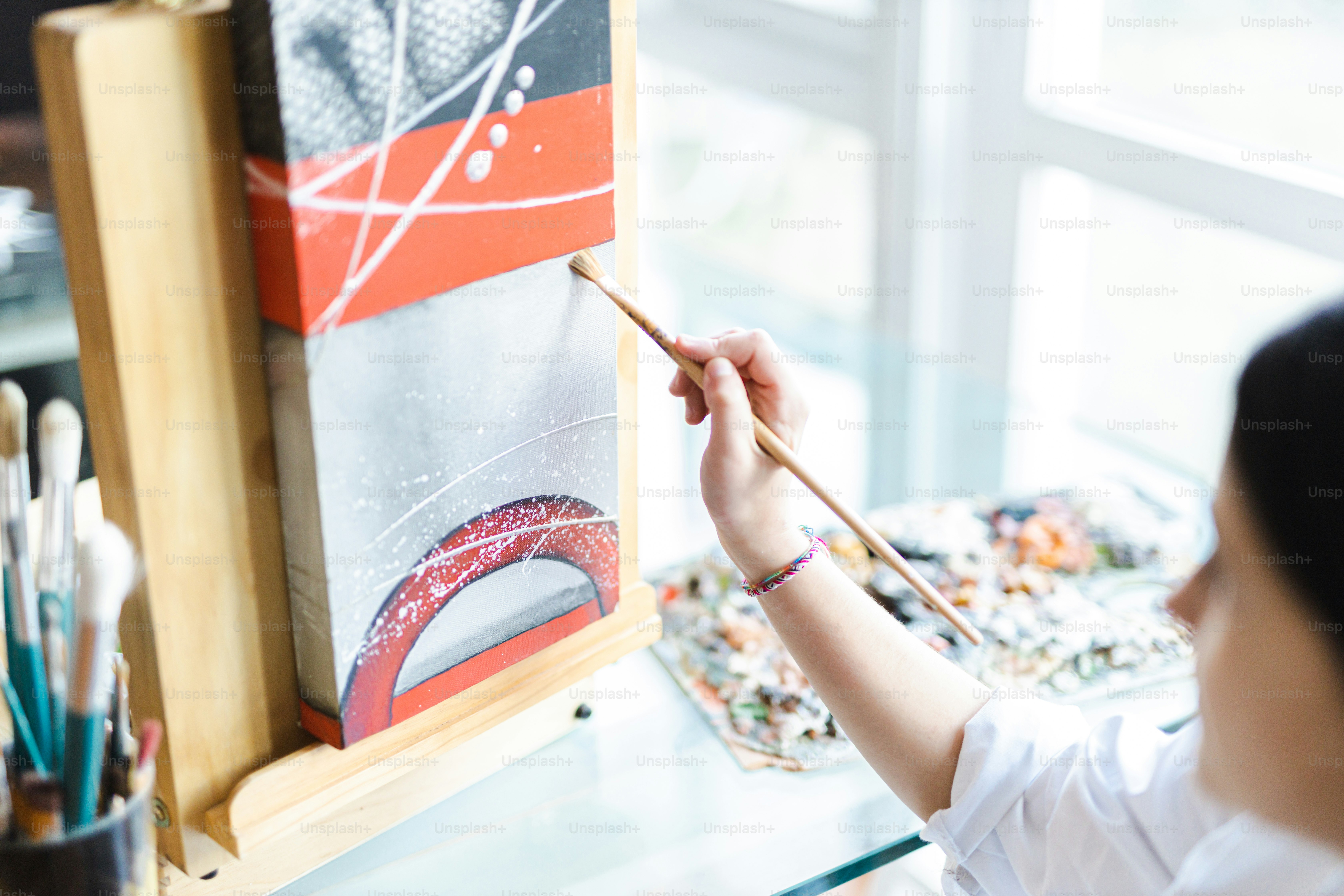 A woman is painting a picture on a easel photo – Painting Image on Unsplash