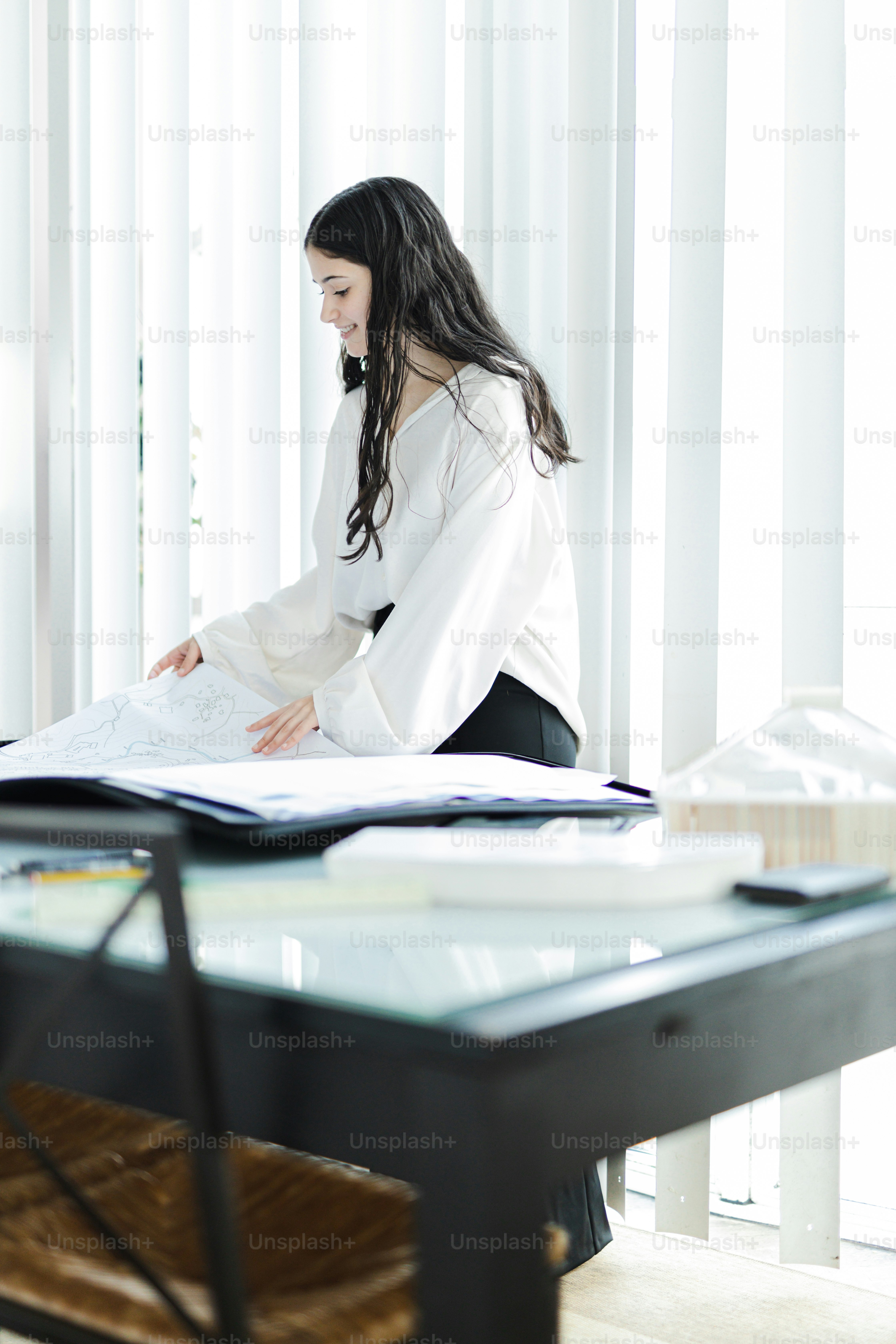 Une femme assise à une table regardant un morceau de papier