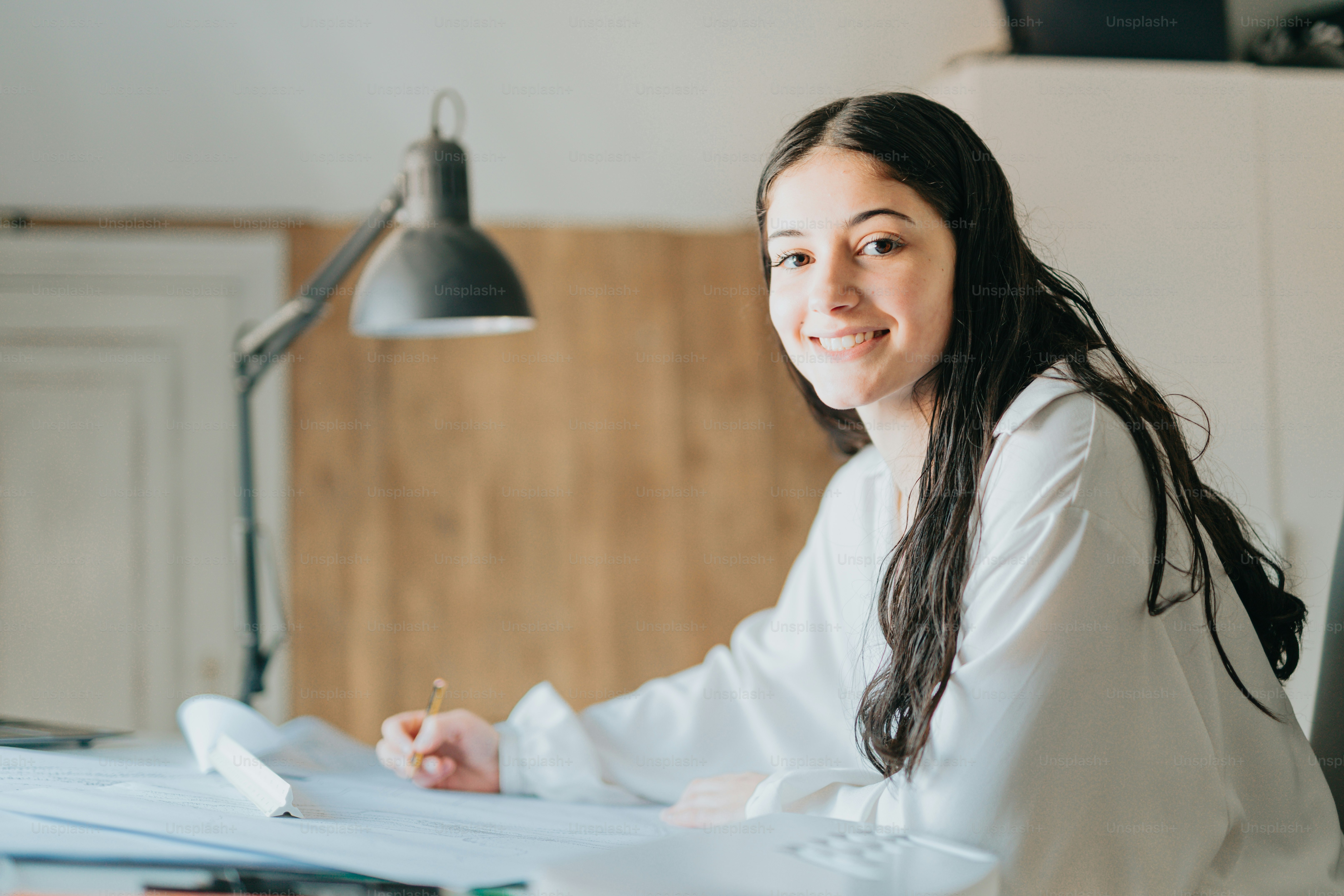 une femme assise à un bureau avec un stylo et du papier