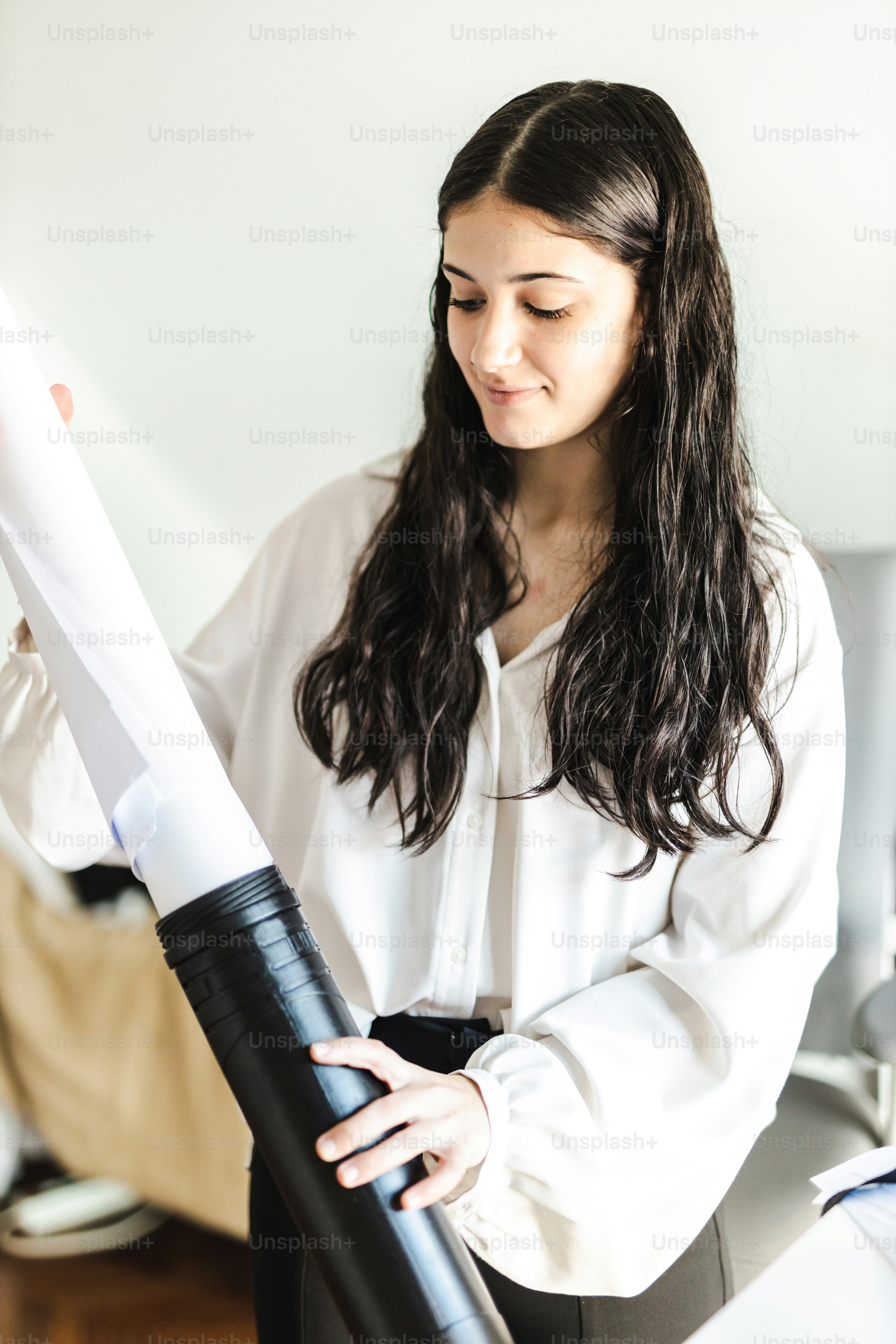 Une femme en chemise blanche tenant un parapluie noir et blanc