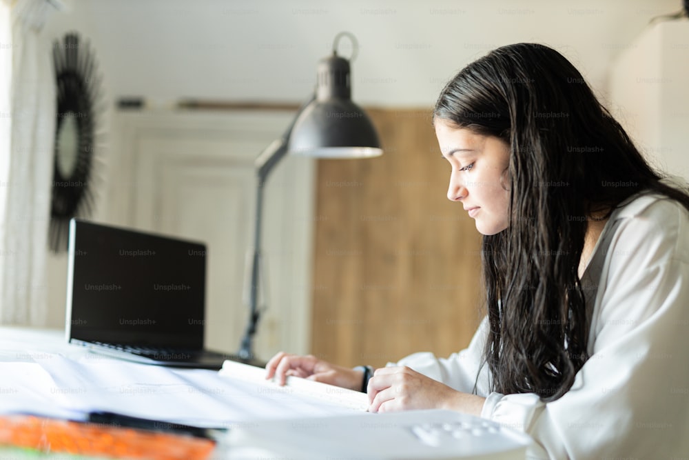 Una donna seduta a una scrivania che lavora su un computer portatile